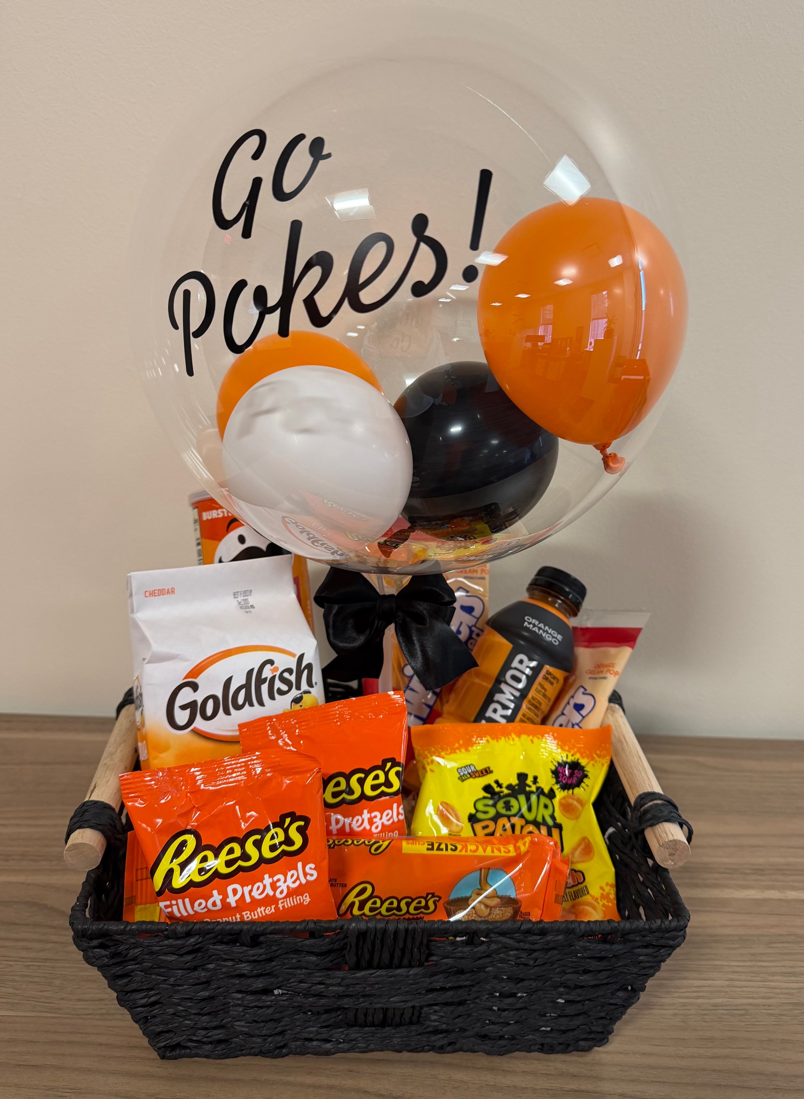 Go Pokes! OSU themed snack gift basket with orange and black balloon arrangement.