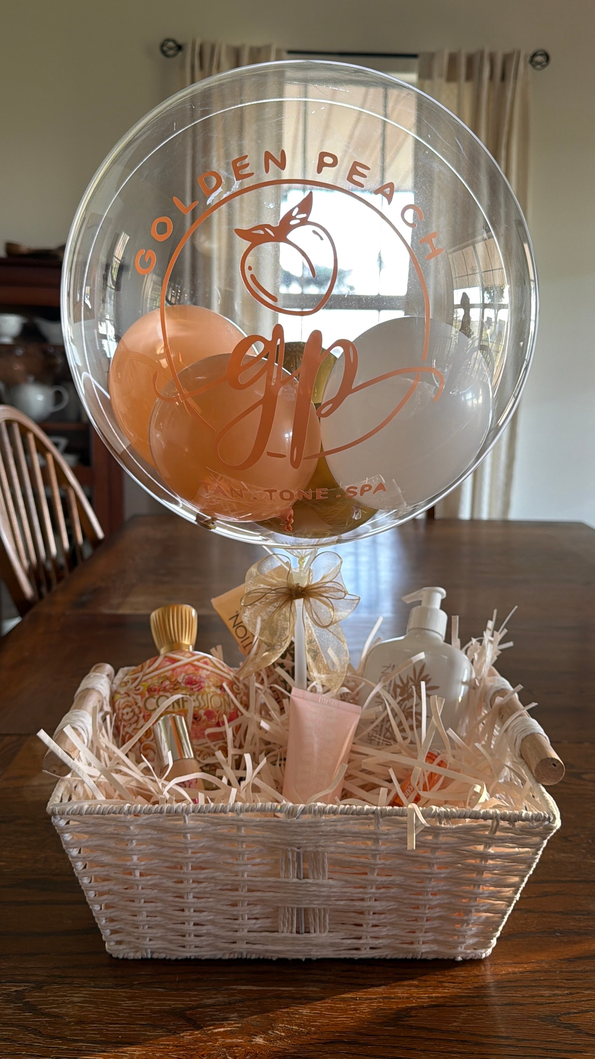 Golden Peach spa gift basket with custom branded balloon arrangement.