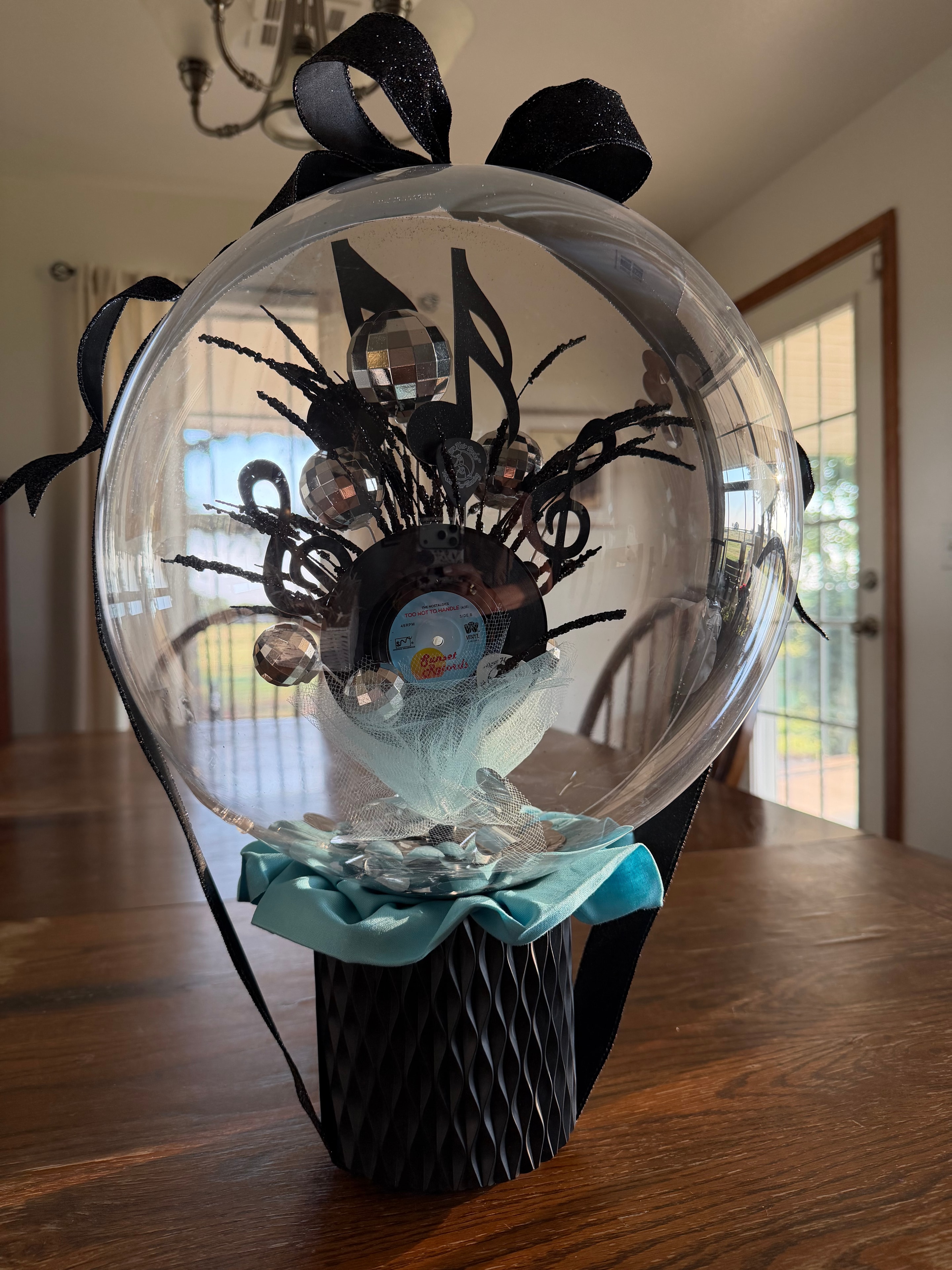 Music-themed balloon gift with vinyl record, disco balls, and turquoise bow.